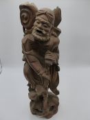 AN ORIENTAL CARVED HARDWOOD FIGURE OF A WIZENED TRAVELLER. 46 CMS. HIGH