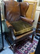A GOOD QUALITY GEORGIAN STYLE LEATHER UPHOLSTERED WING ARMCHAIR