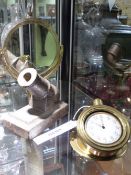 AN EARLY 20TH.C.BRASS CASED DASHBOARD POCKET WATCH HOLDER TOGETHER WITH A SMALL CAST IRON CANON