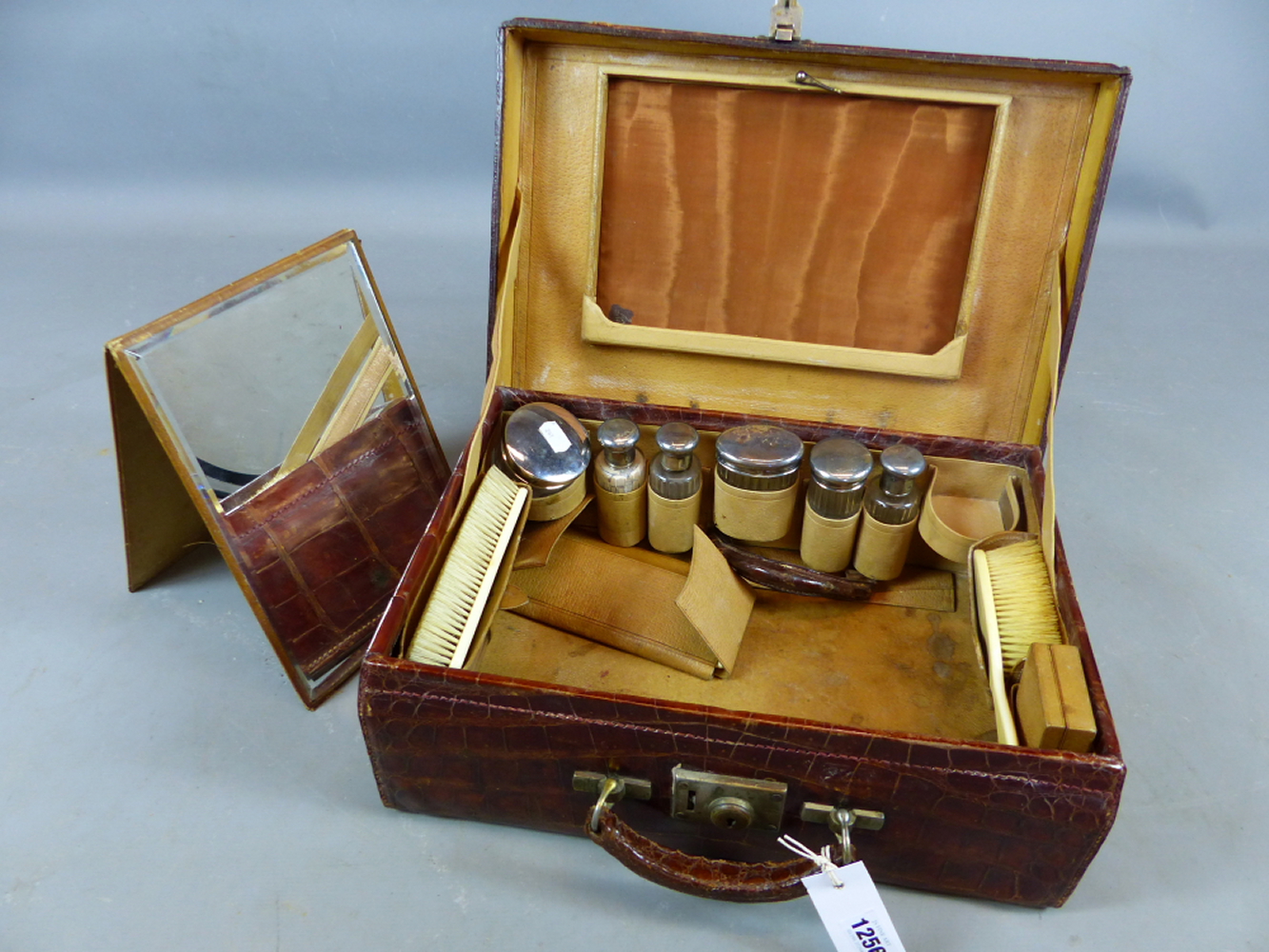 A CROCODILE SKIN TRAVELLING VANITY CASE FITTED WITH VARIOUS GLASS AND WHITE METAL DRESSING TABLE - Image 5 of 10