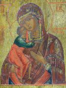 A RUSSIAN ICON PAINTED ON PANEL DEPICTING THE MADONNA AND CHILD, 35 X 31CM.