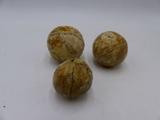 THREE ANTIQUE FEATHER FILLED HIDE BALLS OF FEATHERY GOLF BALL TYPE.