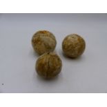 THREE ANTIQUE FEATHER FILLED HIDE BALLS OF FEATHERY GOLF BALL TYPE.