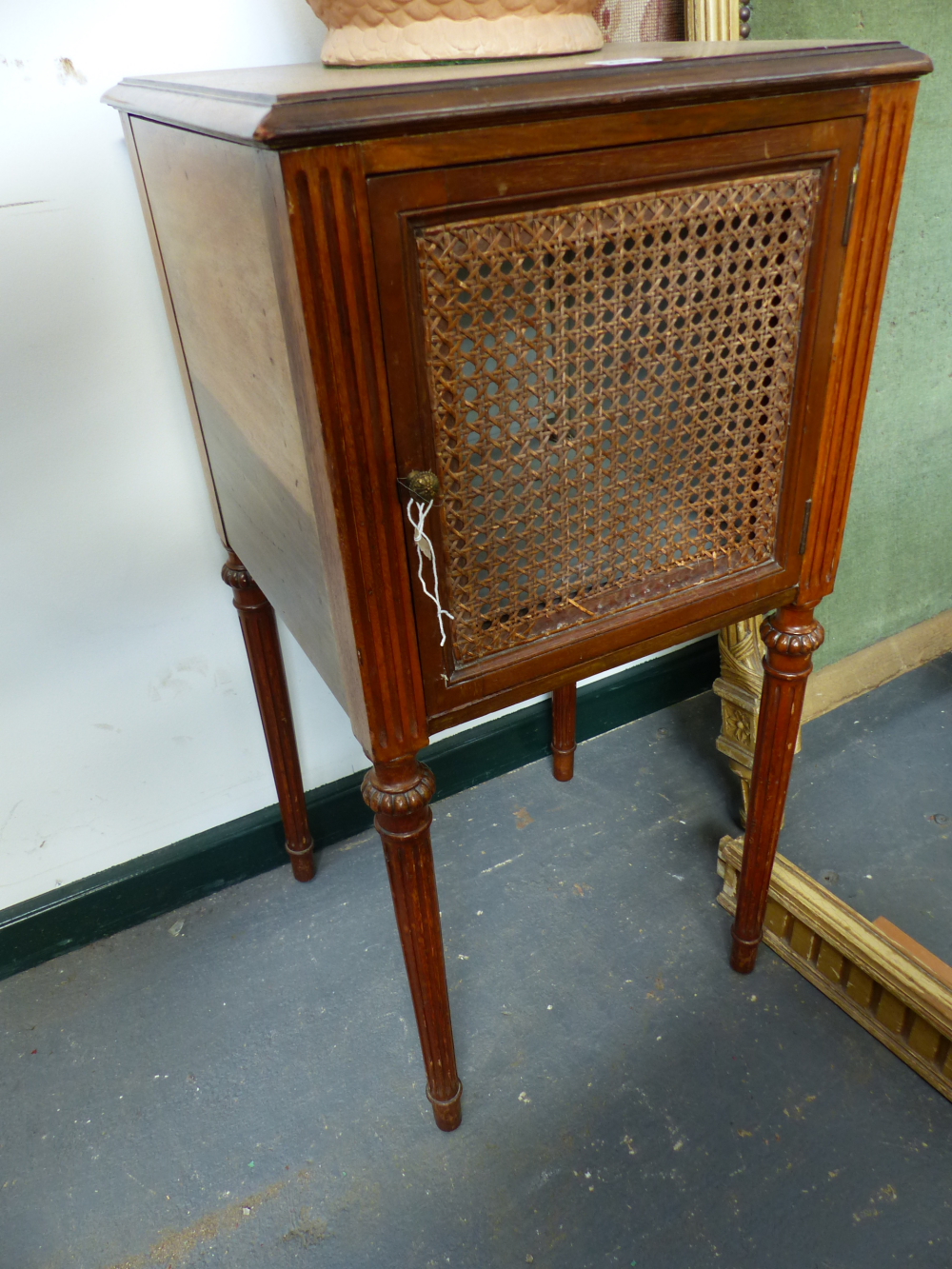 A PAIR OF FRENCH WALNUT BEDSIDE CABINETS WITH CANE PANEL DOORS.