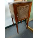 A PAIR OF FRENCH WALNUT BEDSIDE CABINETS WITH CANE PANEL DOORS.