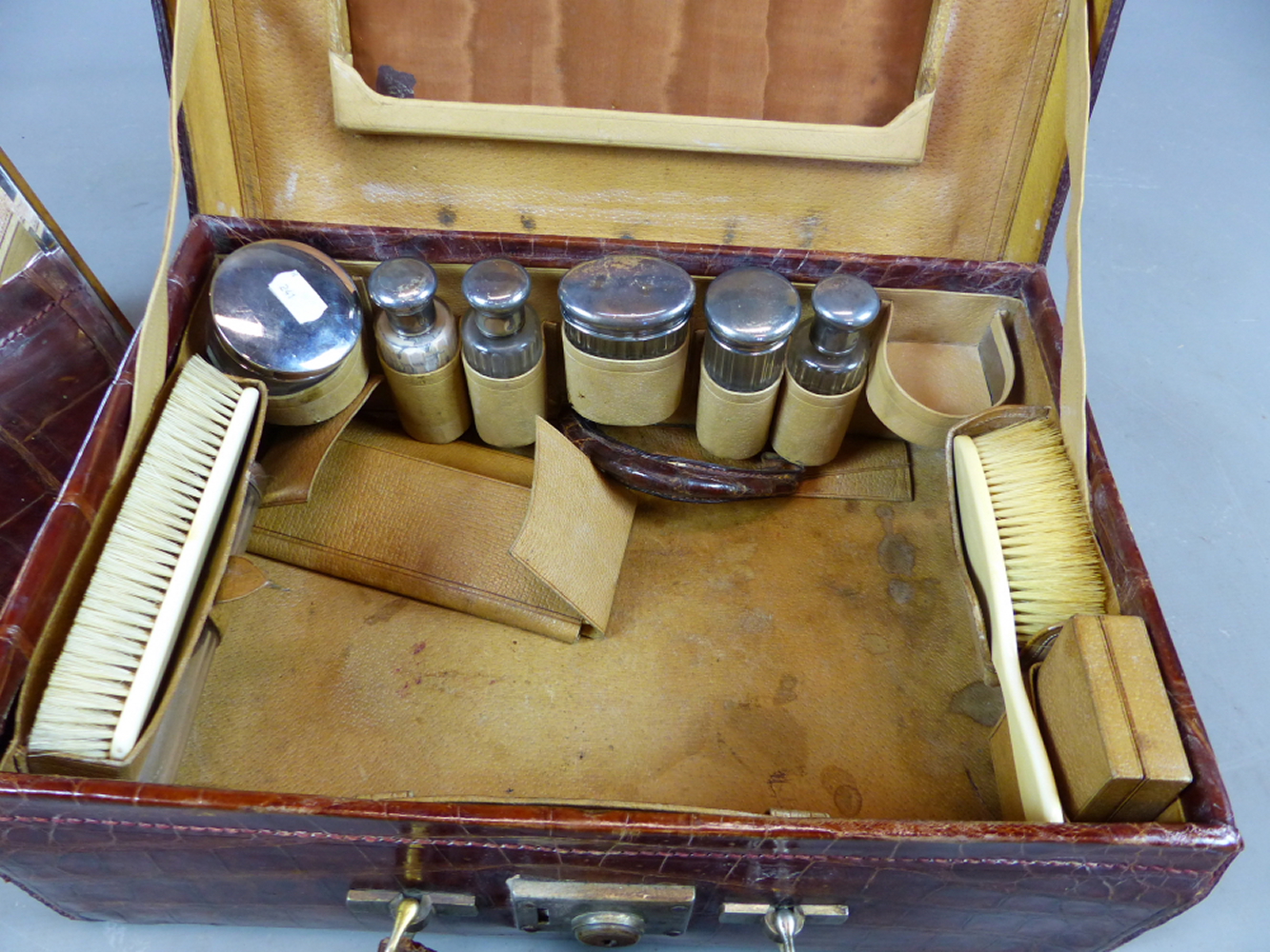 A CROCODILE SKIN TRAVELLING VANITY CASE FITTED WITH VARIOUS GLASS AND WHITE METAL DRESSING TABLE - Image 6 of 10