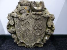 AN EARLY CARVED STONE ARMORIAL CARTOUCHE WITH CENTRAL SHIELD FRAMED BY SCROLLWORK. H.55CMS.