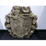 AN EARLY CARVED STONE ARMORIAL CARTOUCHE WITH CENTRAL SHIELD FRAMED BY SCROLLWORK. H.55CMS.