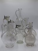 A VICTORIAN GLASS CLARET JUG WITH FINELY ETCHED FOLIATE SWAGS CENTERING A MONOGRAM AND FAMILY CREST.