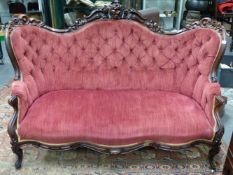 A GOOD VICTORIAN CARVED ROSEWOOD SHOW FRAME BUTTON UPHOLSTERED SALON SETTEE.