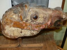 A LATE 19TH.C.CARVED WOOD CAROUSEL HORSE'S HEAD WITH REMNANTS OF ORIGINAL PAINT, NOW MOUNTED ON