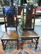 TWO CARVED OAK ANTIQUE PANEL BACK SOLID SEAT CHAIRS WITH TURNED FRONT LEGS AND STRETCHERS.