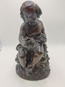 AN ANTIQUE CARVED WOOD FIGURE OF A SEATED CHILD HOLDING FLOWERS. 37CMS HIGH.