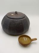 A RARE JANET LEACH FOR LEACH POTTERY. A CUT SIDED BLACK POTTERY BOWL AND COVER, THE LID WITH PARTIAL