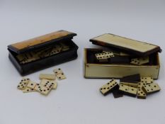 A TWO TONE TORTOISE SHELL HINGED BOX CONTAINING IVORY DOMINOS TOGETHER WITH ONE SLIGHTLY LARGER