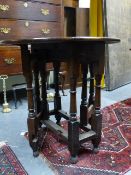 A SMALL ANTIQUE OAK GATE LEG TABLE WITH APRON DRAWER ON RING TURNED LEGS.