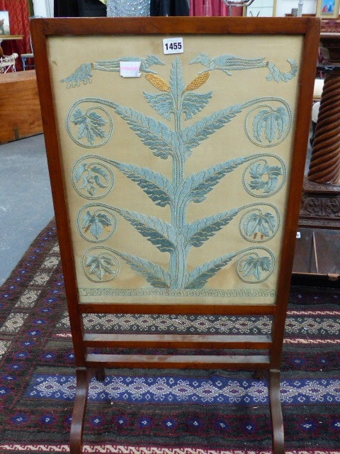 AN ARTS AND CRAFTS SILKWORK PANEL MOUNTED AS A FIRESIDE SCREEN, STYLISED LEAVES SURMOUNTED BY WINGED