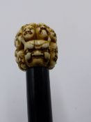 A 19TH CENTURY JAPANESE CARVED IVORY WALKING CANE TOP CARVED WITH MULTIPLE DEITIES FACES AND ONI,