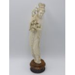 AN EARLY 20TH.C.CHINESE CARVED IVORY STANDING FIGURE OF A MAIDEN HOLDING FRUIT ON A PIERCED HARDWOOD