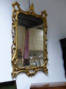 AN ANTIQUE CARVED GILTWOOD PIER MIRROR IN THE GEORGIAN TASTE WITH PIERCED SCROLLWORK FRAME AND