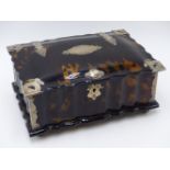 A FLUTED AND DOMED TORTOISE SHELL HINGED BOX WITH WHITE METAL BOUND CORNERS AND NAME PLATES. (