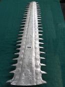 AN INTERESTING CAST ALLOY SAWFISH ROSTRUM ON A LIMESTONE BASE. 99CMS HIGH OVERALL.