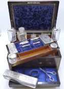 A ROSE WOOD AND BRASS INLAID DRESSING CASE FITTED WITH VARIOUS GLASS AND WHITE METAL TOPPED JARS AND