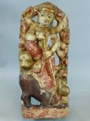 AN EASTERN CARVED AND POLYCHROME MARBLE FIGURAL GROUP OF A DEITY AND ANIMALS WITH GILT HIGHLIGHTS.