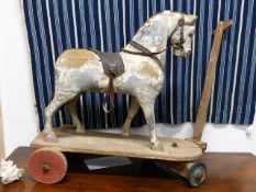 AN ANTIQUE CARVED AND DECORATED CHILD'S PULL TOY HORSE.