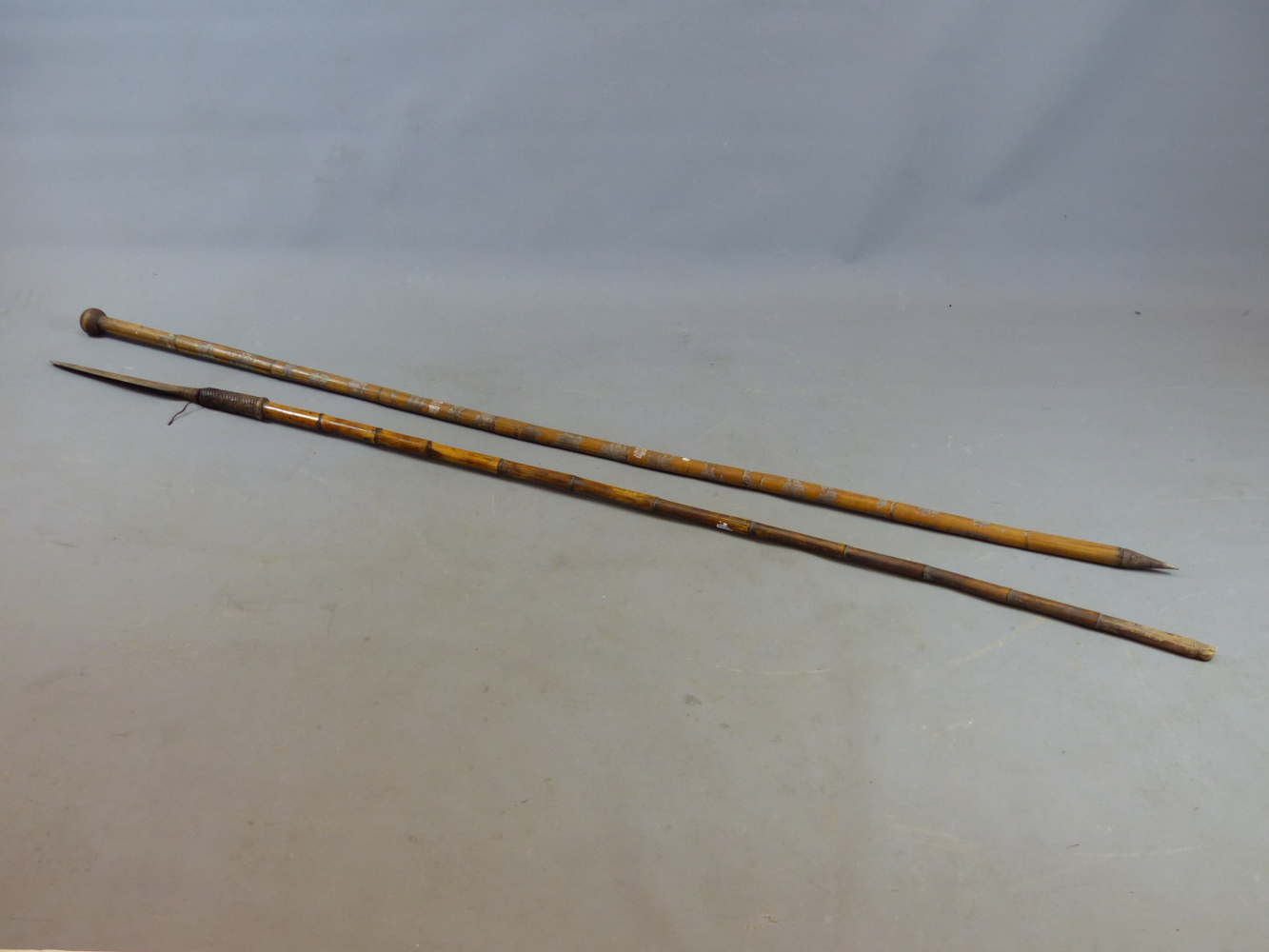 A BAMBOO SHAFTED IRON HEAD SPEAR WITH WOVEN BINDING, PROBABLY AFRICAN TOGETHER WITH A FURTHER BAMBOO