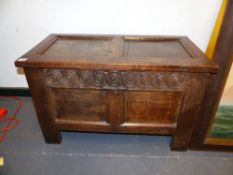 A SMALL 18TH.C.OAK BLANKET COFFER WITH PANELLED TOP OVER CARVED FRIEZE AND TWO PANEL FRONT. 82CMS