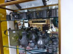 AN EXTENSIVE COLLECTION OF ANTIQUE PEWTER MEASURES, JUGS AND A DECORATED TOLE WATERING CAN.