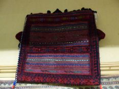 A TRIBAL SADDLE BAG AND A MIXED TECHNIQUE ETHNIC HANGING.