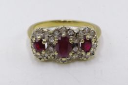 A 9CT. YELLOW GOLD RUBY AND DIAMOND TRIPLE CLUSTER RING.