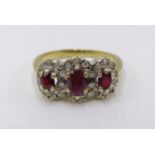 A 9CT. YELLOW GOLD RUBY AND DIAMOND TRIPLE CLUSTER RING.