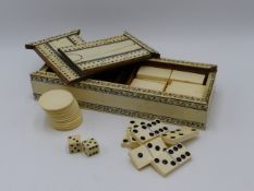 AN EARLY 20TH.C.IVORY AND CEDAR WOOD GAMES BOX CONTAINING DOMINOES AND GAMING COUNTERS. 23.5CMS