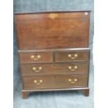 A LATE GEORGIAN OAK BLANKET BOX ON CHEST OF TWO SHORT AND TWO LONG DRAWERS STANDING ON BRACKET FEET.