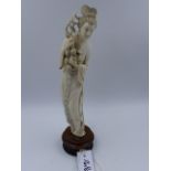 AN EARLY 20th.C.CHINESE CARVED IVORY STANDING FIGURE OF A MAIDEN HOLDING FRUIT ON A PIERCED HARDWOOD