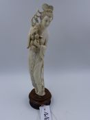 AN EARLY 20th.C.CHINESE CARVED IVORY STANDING FIGURE OF A MAIDEN HOLDING FRUIT ON A PIERCED HARDWOOD