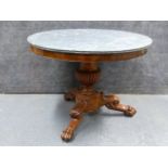 A CARVED MAHOGANY EMPIRE CENTRE TABLE WITH MOULDED EDGE GREY MARBLE TOP ON FLUTED URN PEDESTAL AND