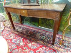 AN EDWARDIAN CARVED MAHOGANY GEO. lll STYLE TWO DRAWER SERPENTINE SIDE TABLE WITH FLUTED APRON,