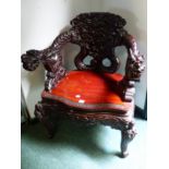 AN ANTIQUE JAPANESE CARVED TUB ARMCHAIR WITH DRAGON FORM BACK AND ARMS.