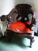 AN ANTIQUE JAPANESE CARVED TUB ARMCHAIR WITH DRAGON FORM BACK AND ARMS.