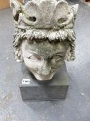 AN ANTIQUE WEATHERED AND CARVED HEAD OF A ROYAL FIGURE WEARING A CROWN, ON A LATER STONE PLINTH.