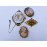 A SELECTION OF FOUR VARIOUS STYLES OF BROOCHES TO INCLUDE TWO CAMEOS, AN OVAL AGATE AND A ROCOCO