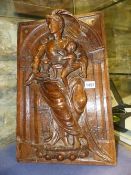 AN EARLY CONTINENTAL CARVED OAK PANEL OF A CLASSICAL LADY HOLDING A CHILD AND A BASKET OF FRUIT.