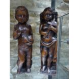 TWO ANTIQUE CARVED OAK STANDING FIGURES, ONE HOLDING A BOOK THE OTHER A CROSS. H.33cms.