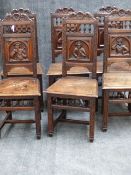 A SET OF SIX ANTIQUE CARVED OAK CONTINENTAL CHAIRS WITH SOLID SEATS, ELABORATE FIGURAL BACK PANELS