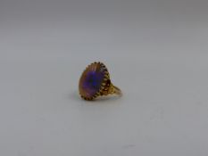 AN EARLY PRECIOUS YELLOW METAL NATURAL OPAL CABOCHON RING. OPAL SIZE APPROXIMATELY 1.8cm x 1.2cms.