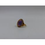 AN EARLY PRECIOUS YELLOW METAL NATURAL OPAL CABOCHON RING. OPAL SIZE APPROXIMATELY 1.8cm x 1.2cms.